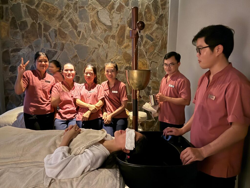 A group administering ayurvedic treatment on Jennifer Andrews